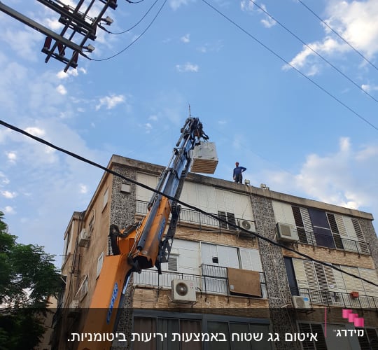 מנוף מרים חומרי בנייה לגג בניין